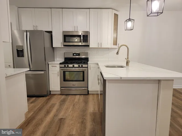 a kitchen with stainless steel appliances a stove microwave and refrigerator