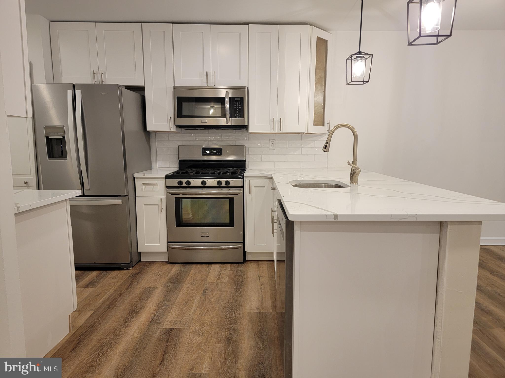 1727 Fitzwater Street, Unit B Philadelphia, PA 19146 - Photo 11 of 31 a kitchen with stainless steel appliances a stove microwave and refrigerator