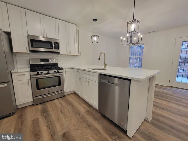 a kitchen with stainless steel appliances granite countertop a sink a stove and microwave