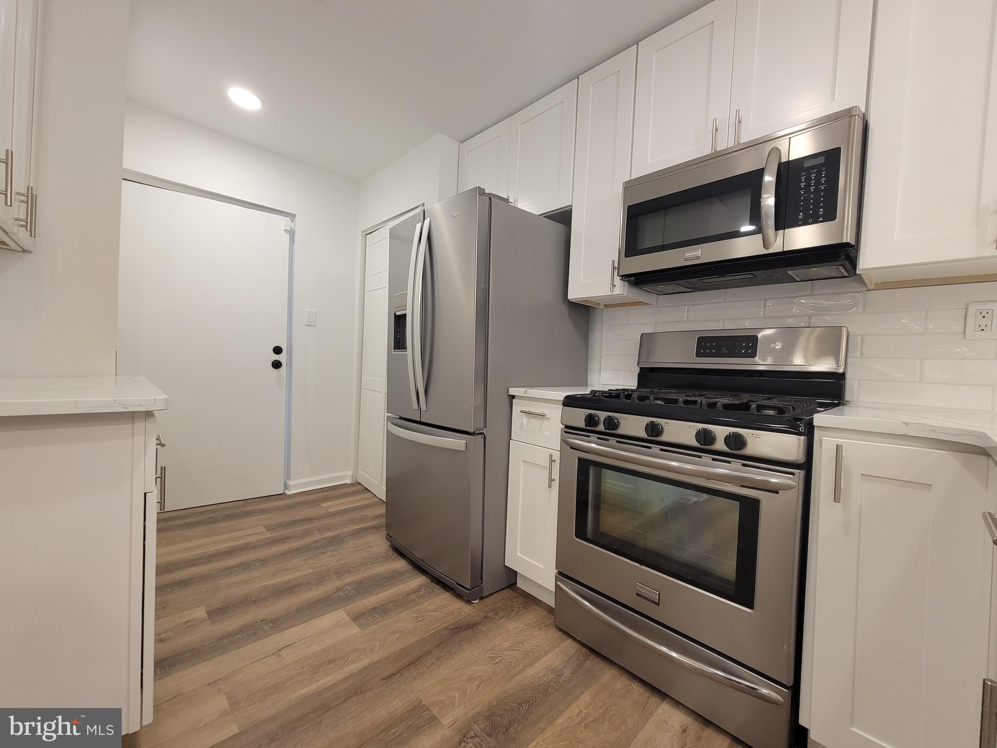 1727 Fitzwater Street, Unit B Philadelphia, PA 19146 - Photo 14 of 31 a kitchen with stainless steel appliances white cabinets a stove a microwave and a refrigerator
