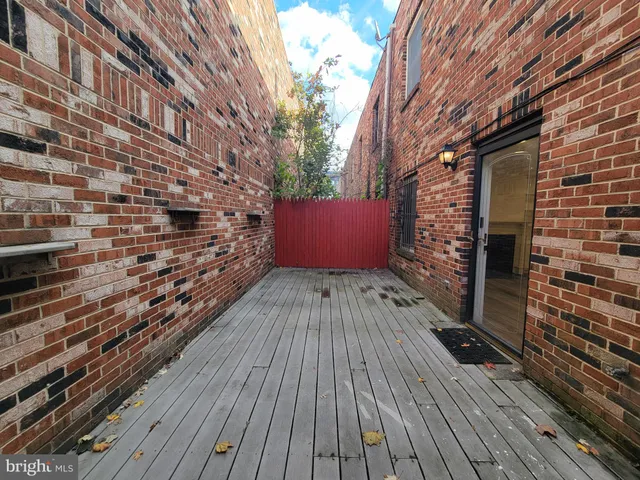a view of outdoor space with wooden floor and brick walls