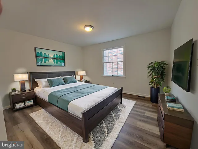 a bedroom with bed tv and window