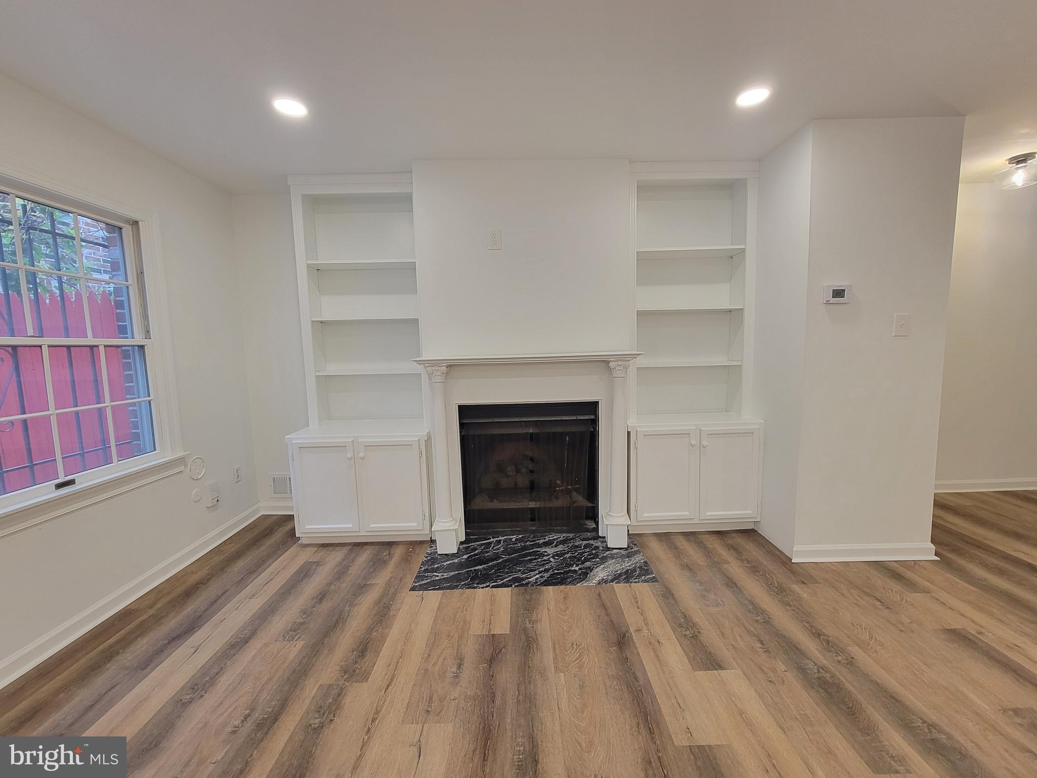 1727 Fitzwater Street, Unit B Philadelphia, PA 19146 - Photo 8 of 31 a view of a livingroom with wooden floor a fireplace and window