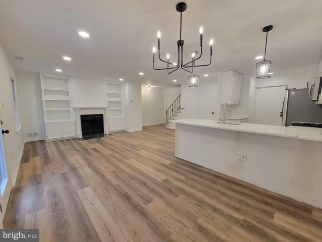 an open kitchen with a sink and chandelier