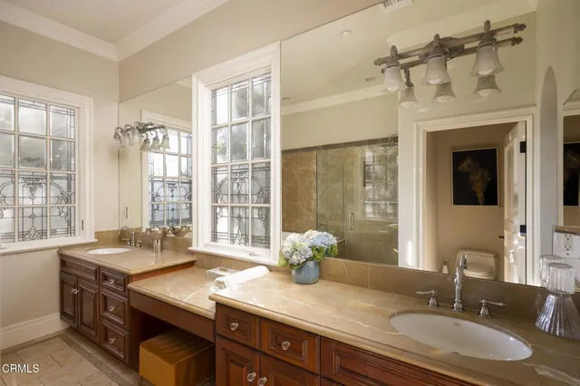 a bathroom with a granite countertop sink and a window