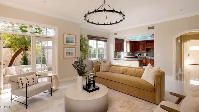a living room with furniture potted plant and kitchen view
