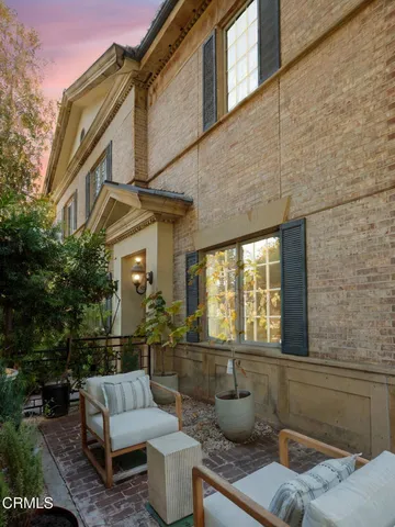 a view of a patio with couches table and chairs and potted plants
