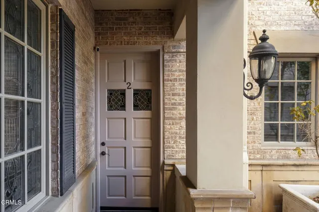 a front view of a house with garden and trees