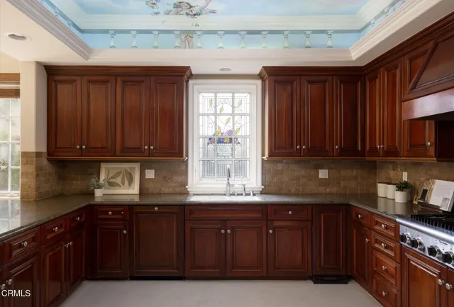 a kitchen with granite countertop wooden cabinets a sink and dishwasher