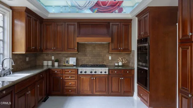 a kitchen with stainless steel appliances granite countertop wooden cabinets and a stove top oven