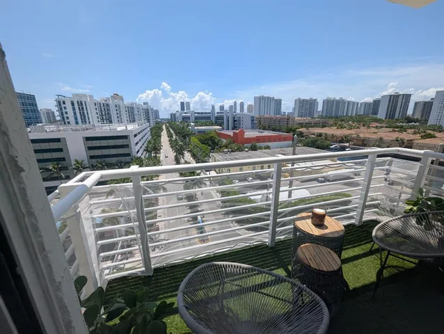 a view of a balcony with chairs and a potted plant