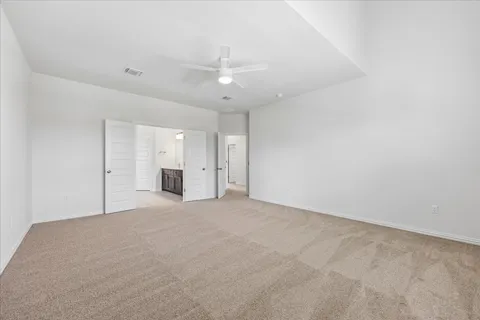 an empty room with fan and windows