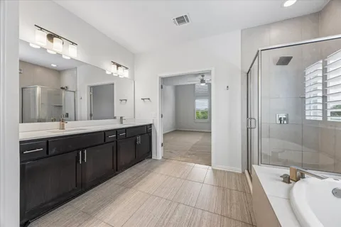 a large bathroom with a glass door shower a sink and a mirror