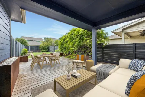 a view of a patio with couches table and chairs and potted plants