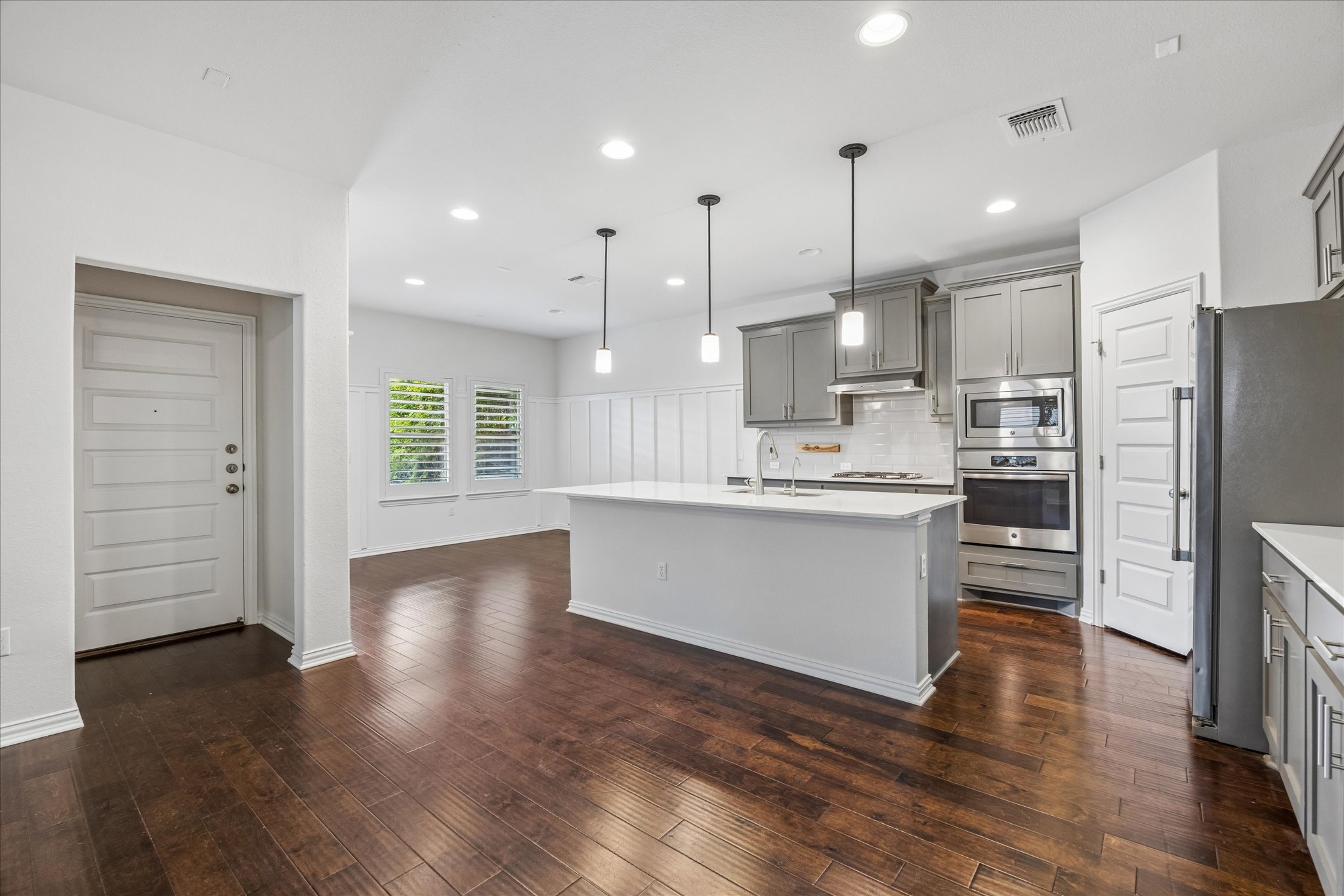 8816 Cattle Baron Path Austin, TX 78747 - Photo 8 of 32 a large kitchen with cabinets wooden floor and stainless steel appliances