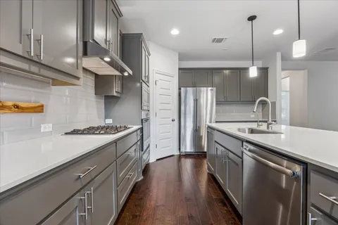 a kitchen with stainless steel appliances granite countertop a sink a stove and a refrigerator