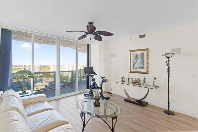 a living room with furniture ceiling fan and a wooden floor