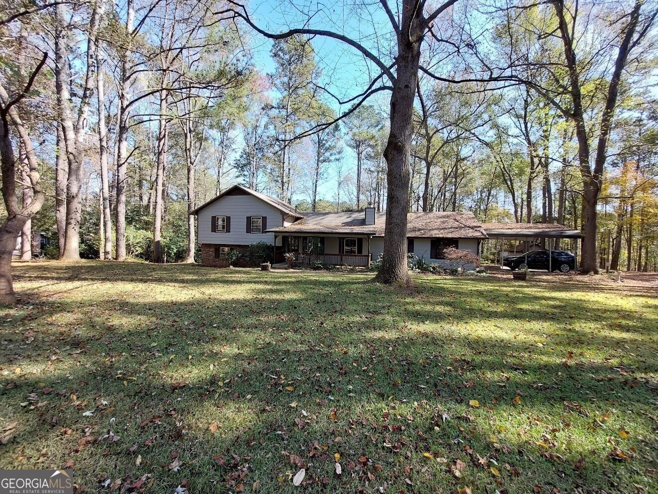 a front view of a house with a yard covered with trees