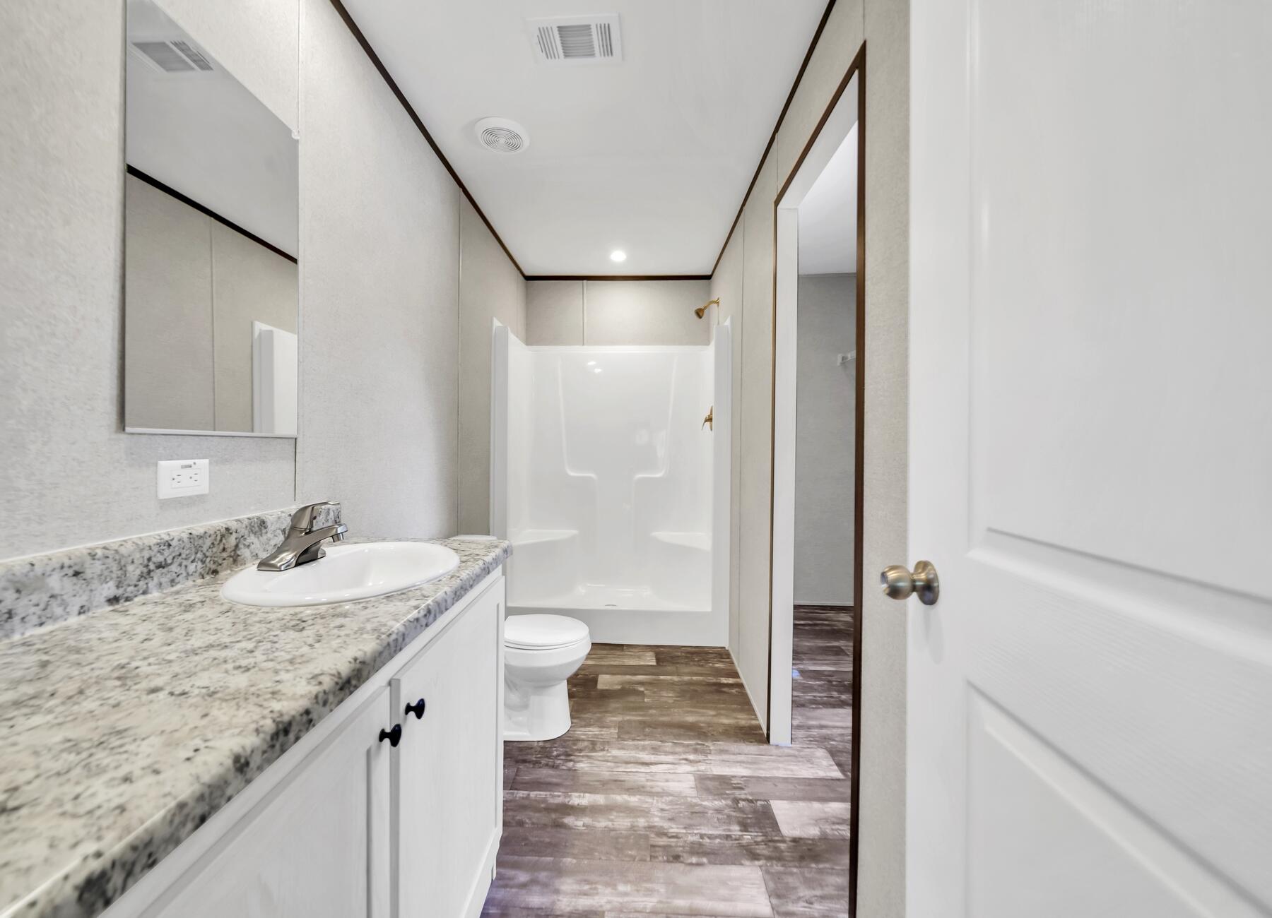 173 Gregory Dean Lane DeFuniak Springs, FL 32433 - Photo 19 of 24 a bathroom with a granite countertop sink a toilet and shower