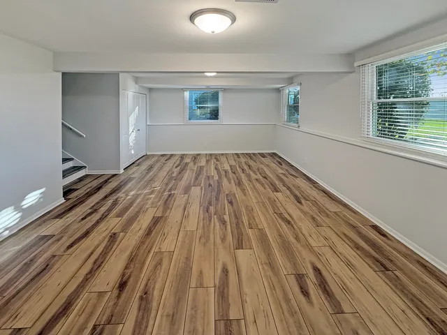 a view of a room with wooden floor and window