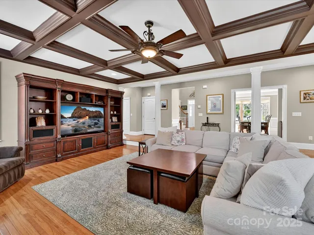 a living room with furniture a flat screen tv and a table