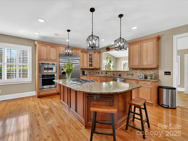 a kitchen with stainless steel appliances granite countertop a stove and cabinets