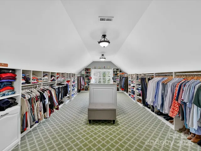 a spacious bedroom with a bed couch and window