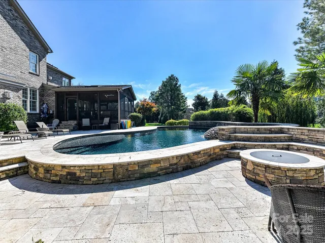 a view of a house with pool and chairs