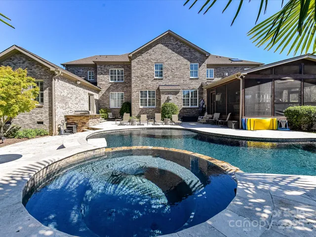a view of a big house with a big yard and large trees