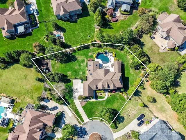 an aerial view of a house with swimming pool garden and patio