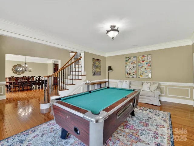 a room with pool table and wooden floor