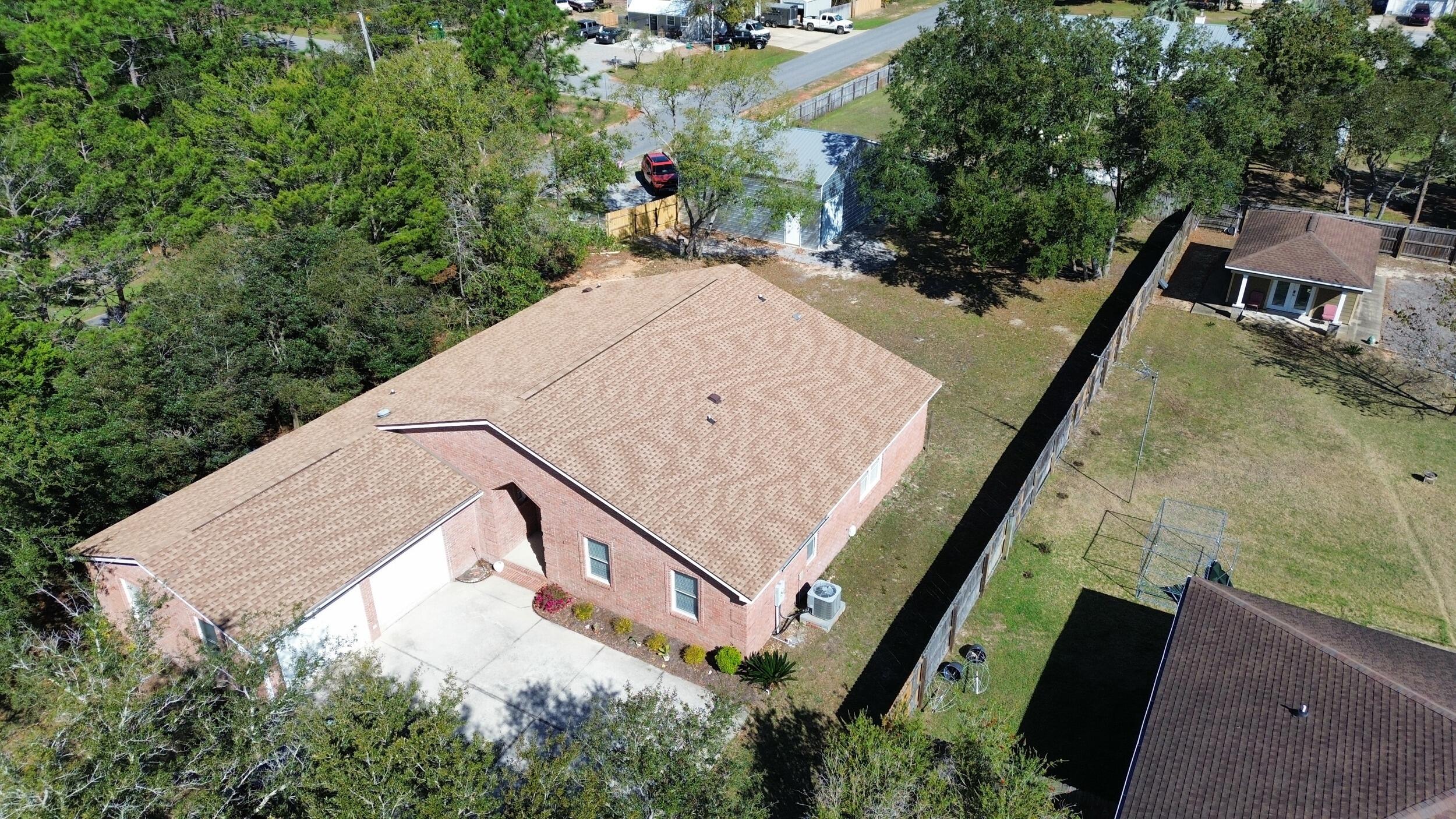 8600 Estrada Street Navarre, FL 32566 - Photo 16 of 63 a view of a backyard with plants and large trees