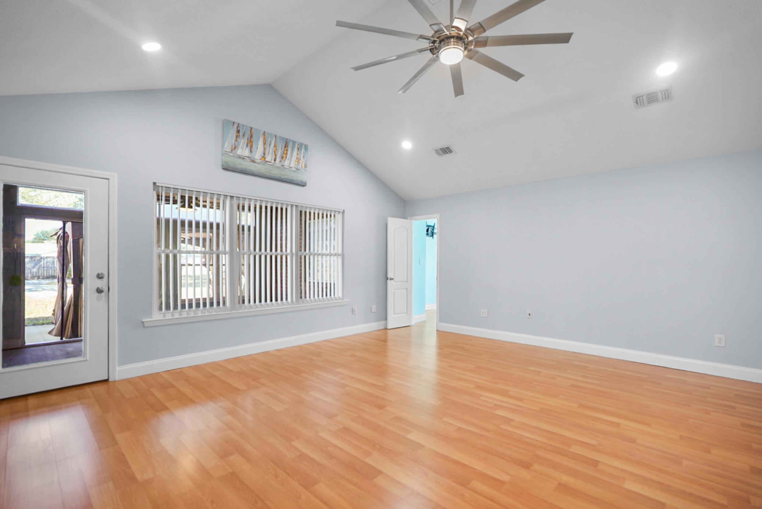 8600 Estrada Street Navarre, FL 32566 - Photo 24 of 63 an empty room with wooden floor fan and windows