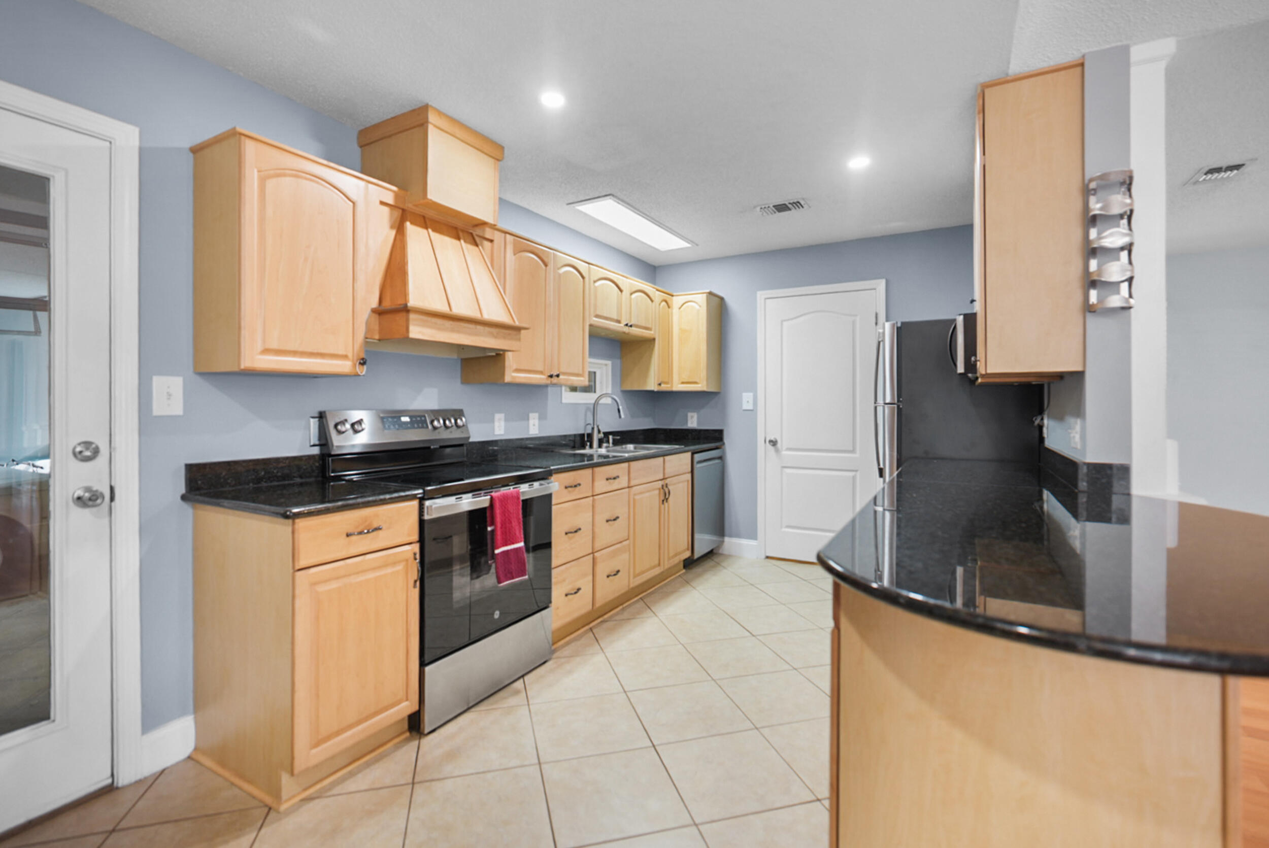 8600 Estrada Street Navarre, FL 32566 - Photo 27 of 63 a kitchen with stainless steel appliances granite countertop a sink a stove and a refrigerator