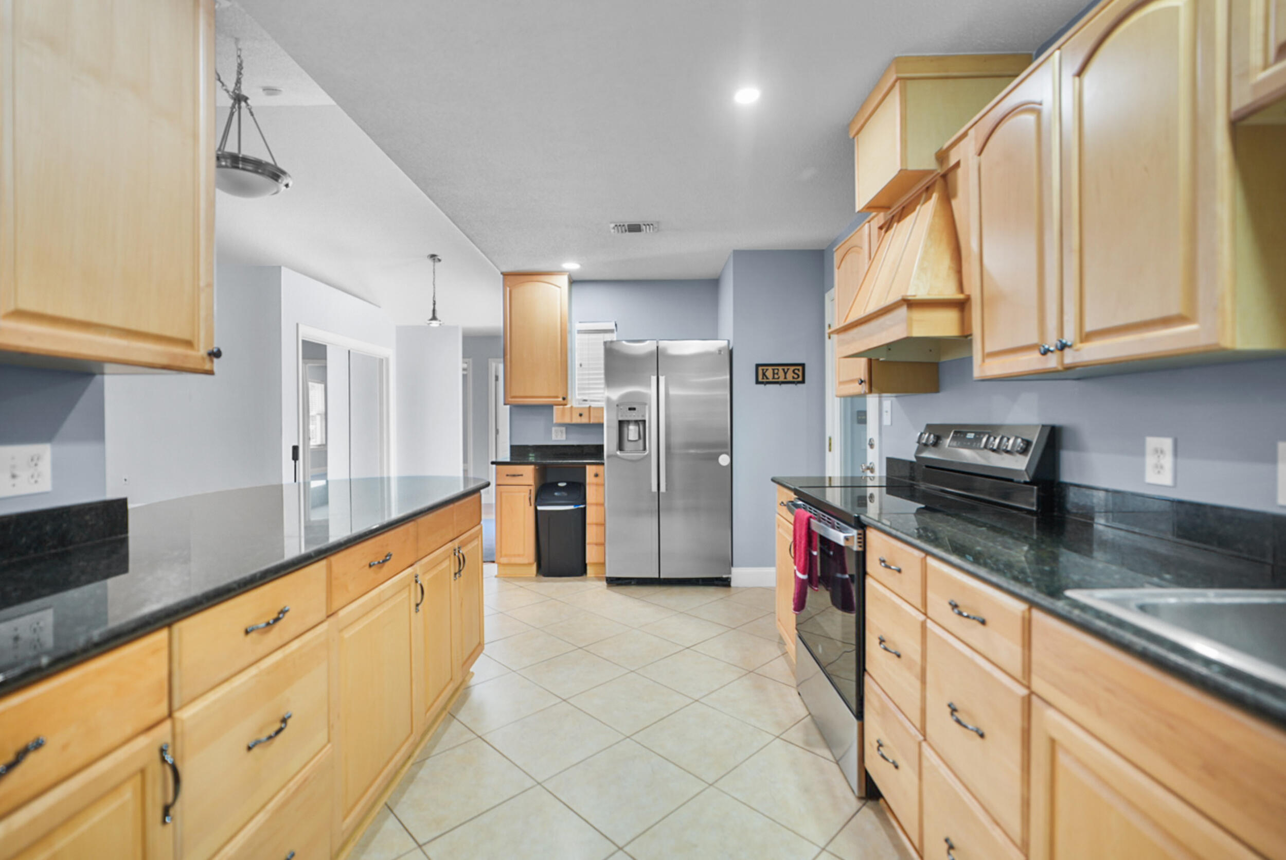8600 Estrada Street Navarre, FL 32566 - Photo 31 of 63 a large kitchen with stainless steel appliances granite countertop a sink and cabinets