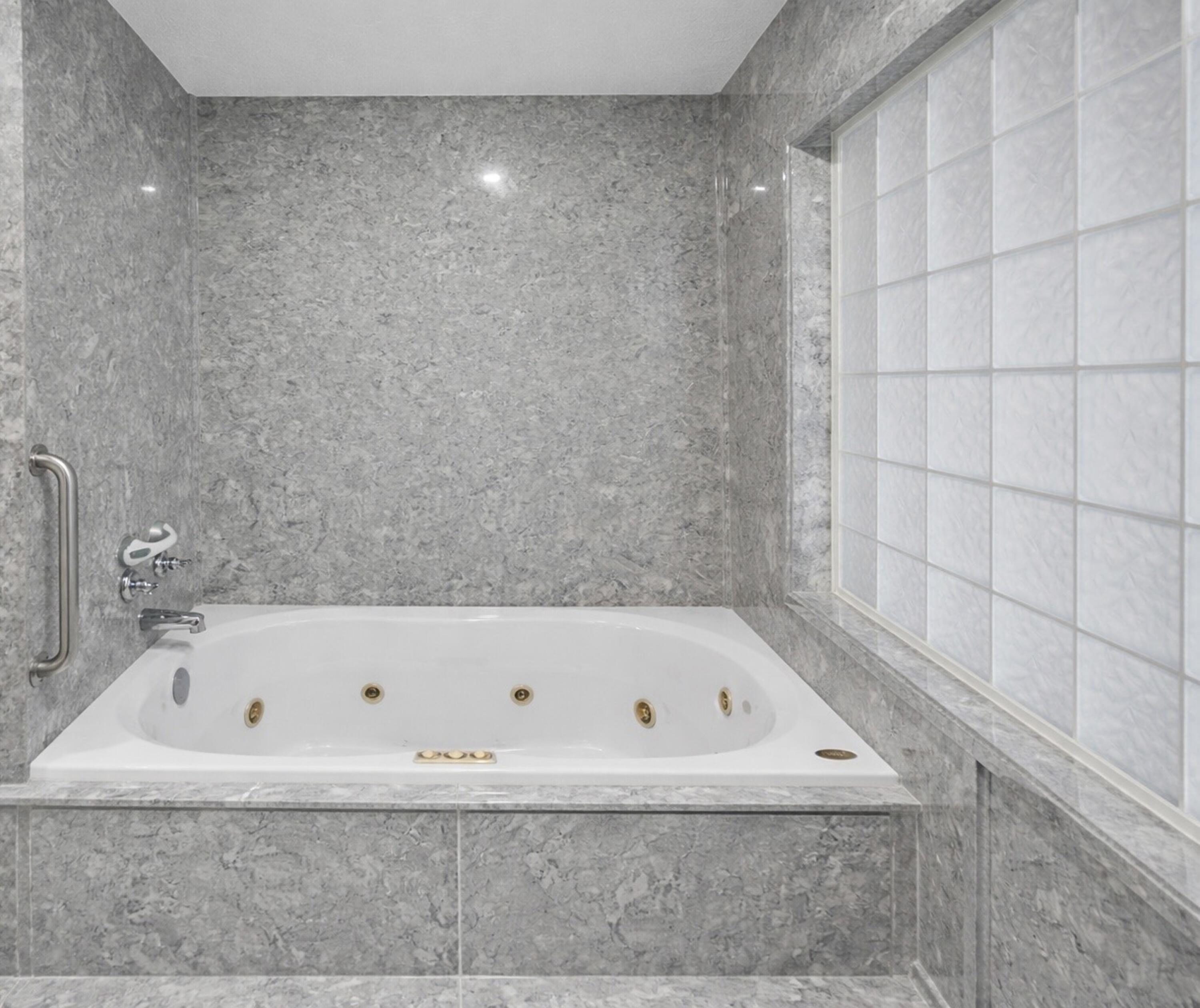 8600 Estrada Street Navarre, FL 32566 - Photo 44 of 63 a bathroom with a bathtub and a shower