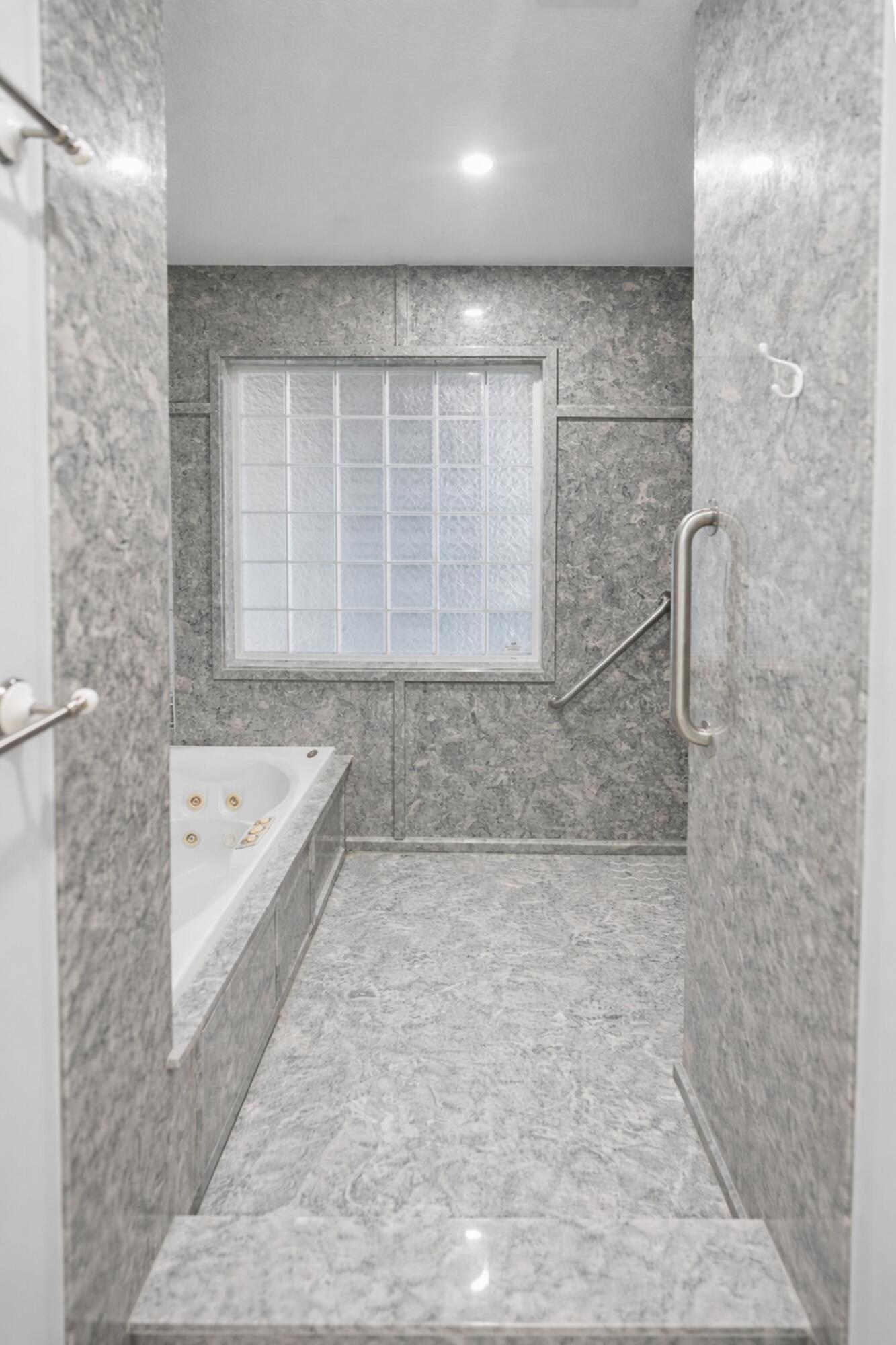 8600 Estrada Street Navarre, FL 32566 - Photo 45 of 63 a bathroom with a bathtub and a shower