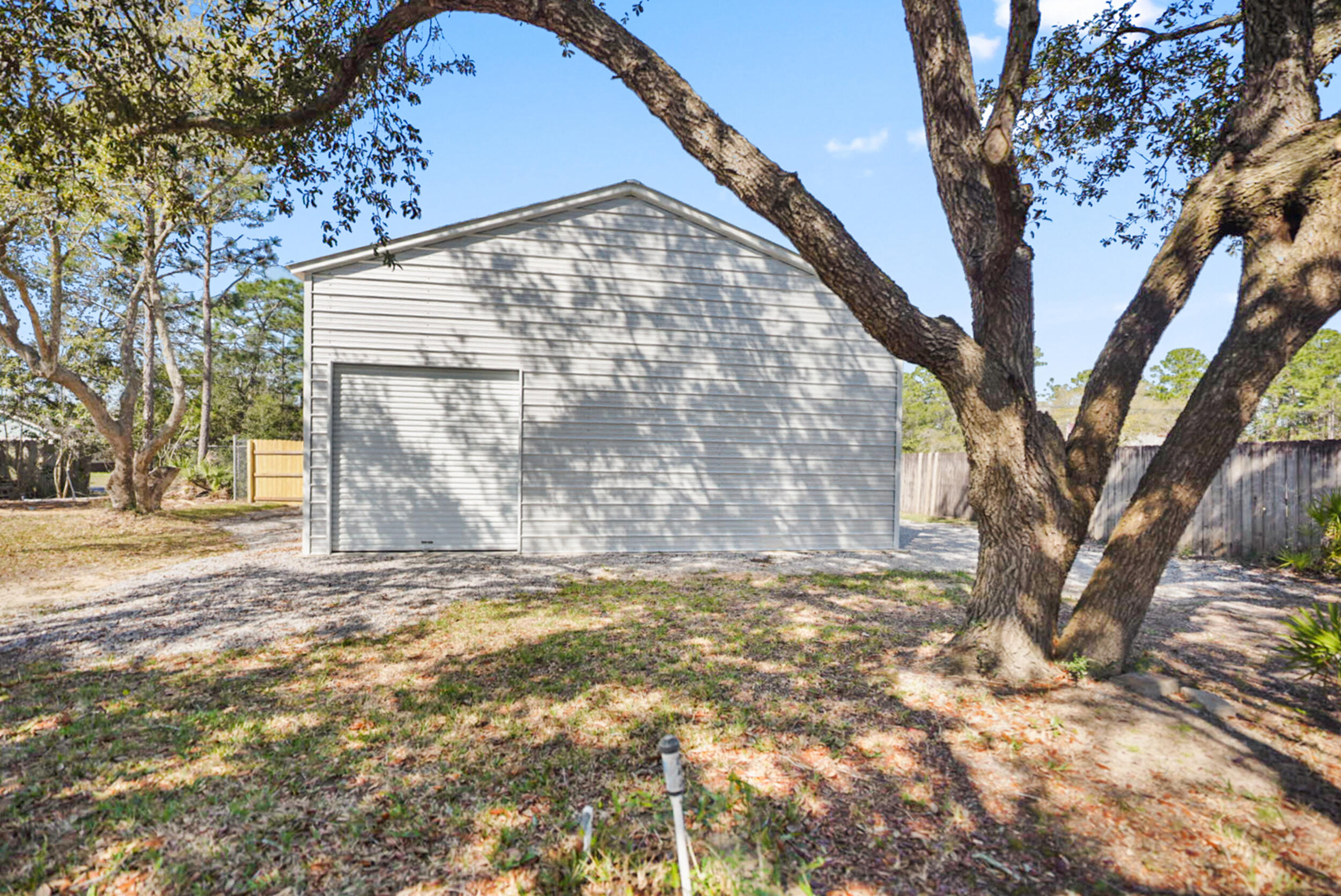 8600 Estrada Street Navarre, FL 32566 - Photo 62 of 63 a view of a yard with a tree
