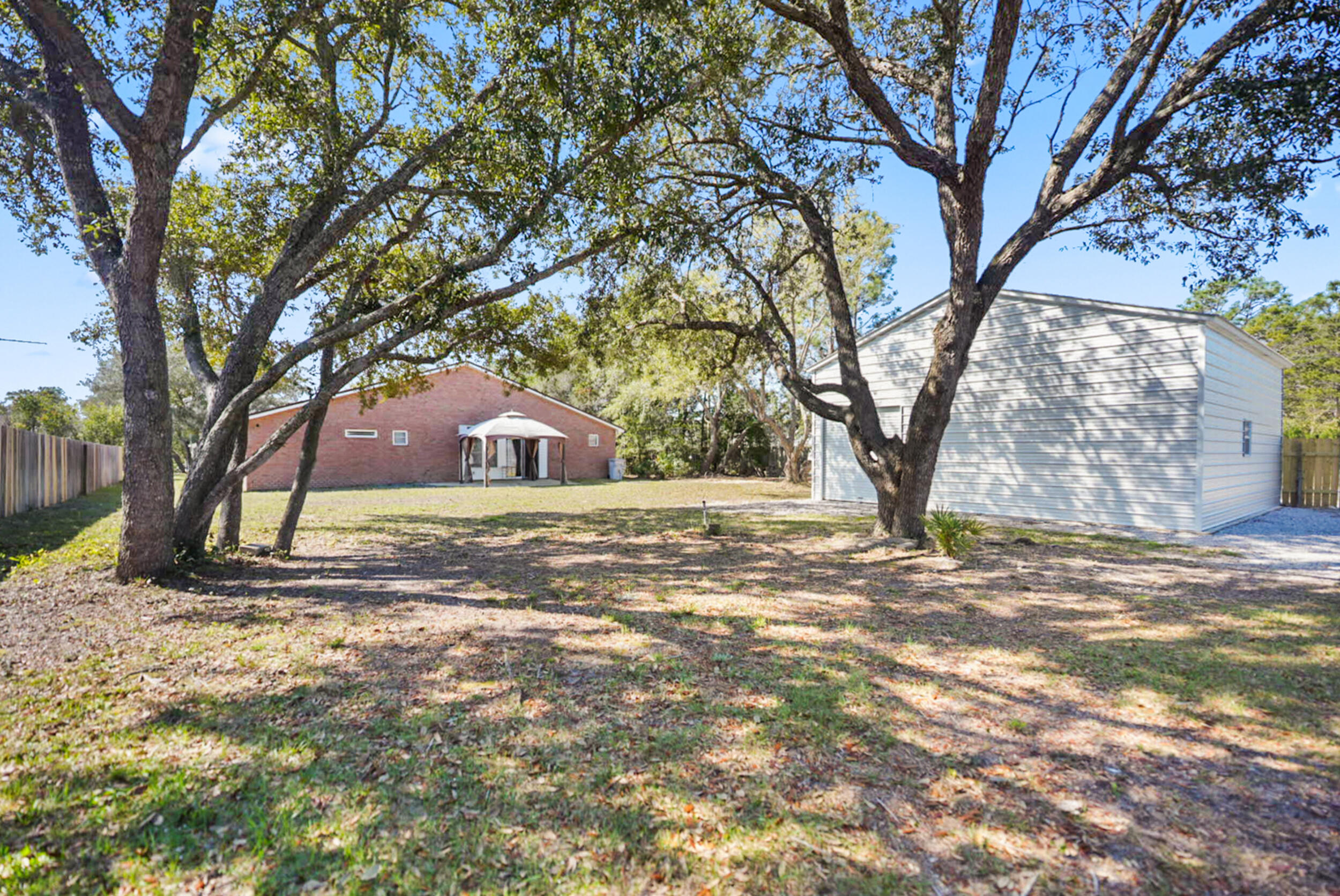 8600 Estrada Street Navarre, FL 32566 - Photo 63 of 63 a view of a yard with trees