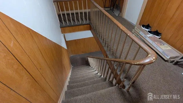 a view of staircase with railing and white walls