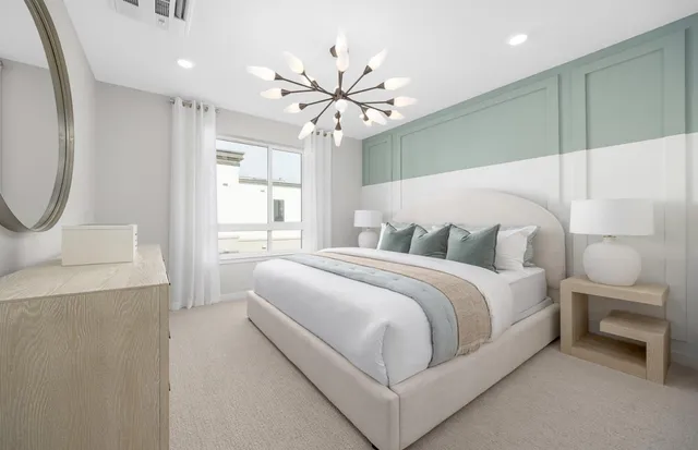 a bedroom with a large bed and a chandelier