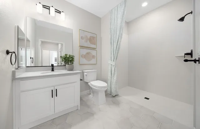 a bathroom with a toilet a sink a mirror and a shower