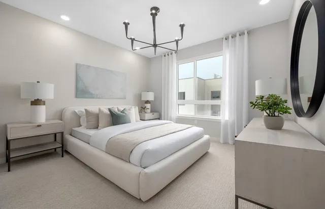 a bedroom with a large bed and a chandelier