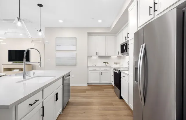 a kitchen with white cabinets and stainless steel appliances