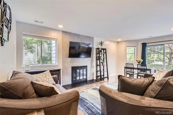 a living room with furniture a flat screen tv and a fireplace