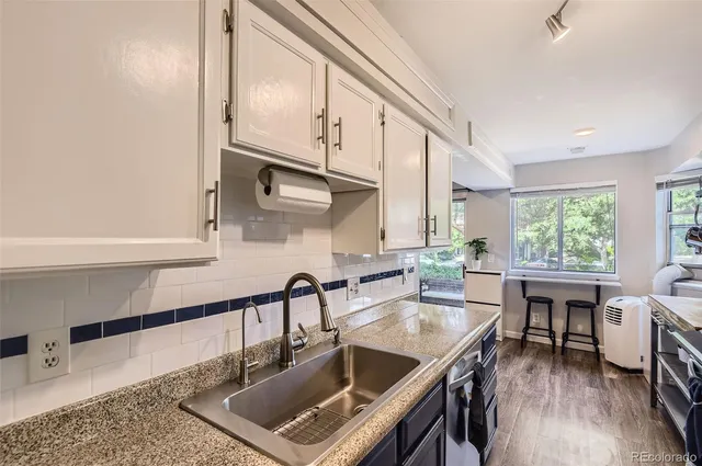 a kitchen with stainless steel appliances granite countertop a sink a stove and a wooden cabinets