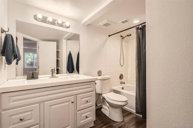 a bathroom with a granite countertop sink toilet a large mirror a vanity and shower