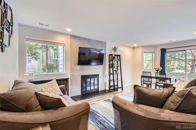 a living room with furniture a flat screen tv and a fireplace