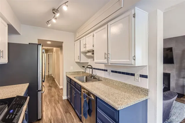 a kitchen with granite countertop a sink stove and cabinets