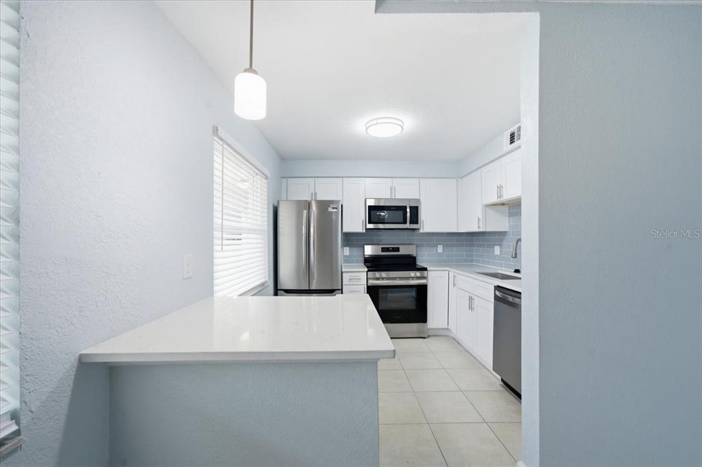 17035 Gulf Boulevard, Unit 118 North Redington Beach, FL 33708 - Photo 16 of 44 a kitchen with stainless steel appliances a refrigerator sink and stove